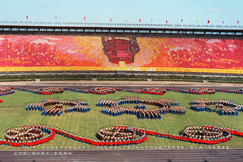 1965年，第二届全运会在北京举行。图为在开幕式上表演的大型团体操《革命赞歌》第三场《自力更生奋发图强》钢水奔流，机轮转动。