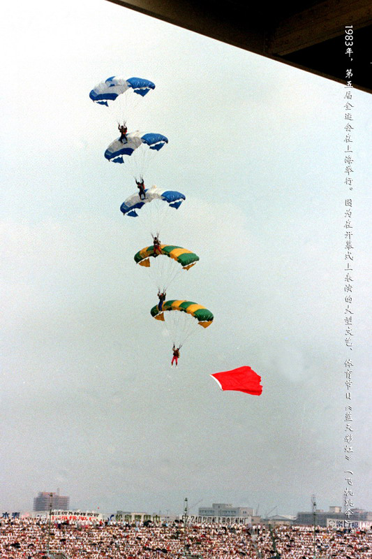 1983年，第五届全运会在上海举行。图为在开幕式上表演的大型文艺、体育节目《蓝天彩虹》（飞机跳伞）。