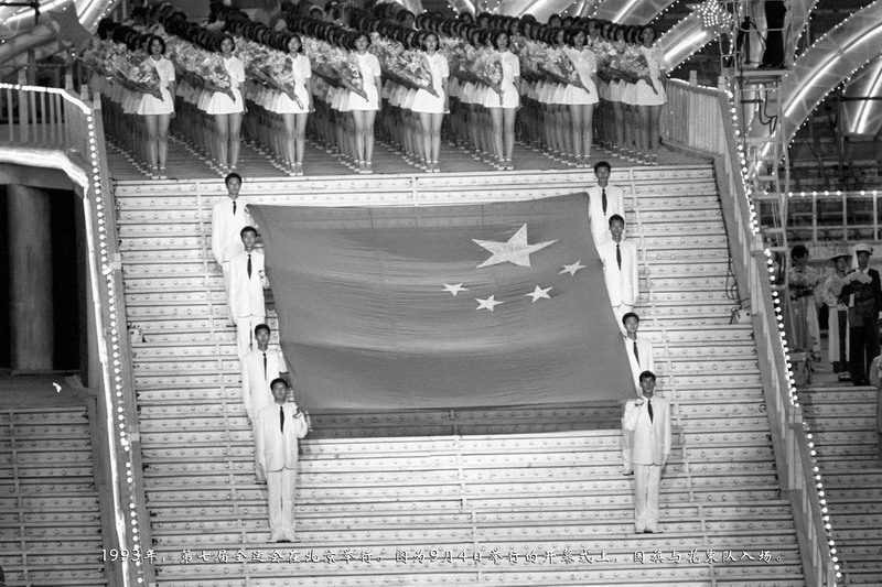 1993年，第七届全运会在北京举行。图为9月4日举行的开幕式上，国旗与花束队入场。