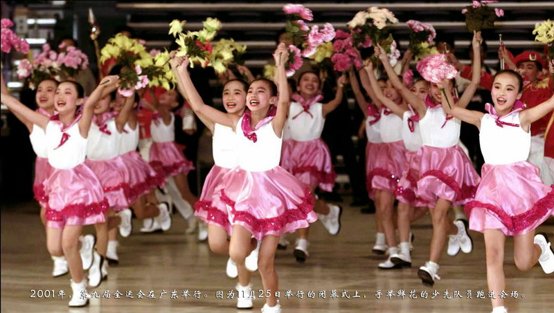2001年，第九届全运会在广东举行。图为11月25日举行的闭幕式上，手举鲜花的少先队员跑进会场。