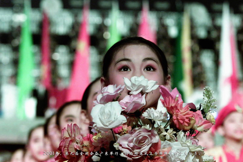 2001年，第九届全运会在广东举行。图为闭幕式上手捧鲜花的少先队员。
