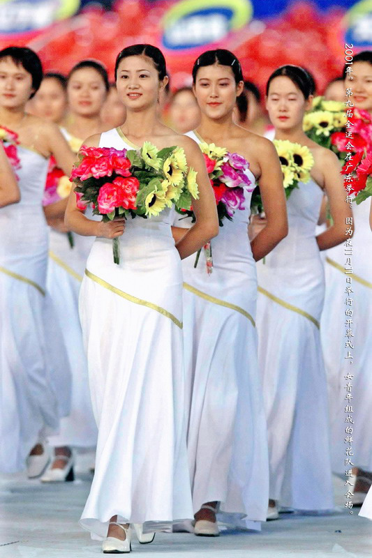 2001年，第九届全运会在广东举行。图为在11月11日举行的开幕式上，女青年组成的鲜花队进入会场。
